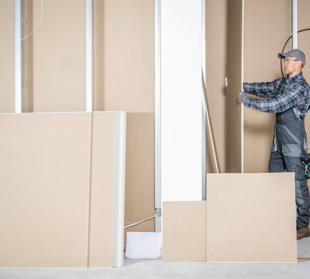 Construction Site Contractor Worker Moving Piece of a Drywall